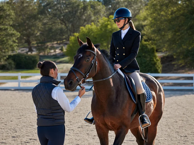 Adulto principiante in casco su cavallo tranquillo, tenuto alla longhina dall'istruttore